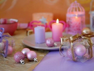 Fototapeta na wymiar Decorative composition in a pink color from burning candles, decorative lanterns, oriental sweets on dishes, Christmas decor, balls on a light silver background, romantic atmosphere, seasonal winter h