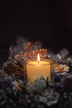 Advent decoration, wreath, candle. In the dark a candle in a beautiful decorative wreath is burning.