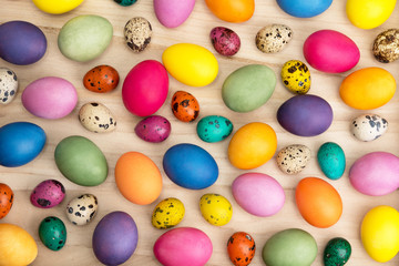 Fototapeta na wymiar colorful easter eggs on a wooden background, top view