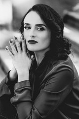 monochrome portrait of stylish modern brunette woman in green blouse sitting on tha stairs