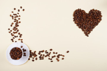 Coffee cup and a heart made of scattered beans.