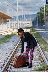 Una ragazza che attraversa i binari nella stazione ferroviaria