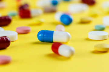 pills are scattered on a yellow background