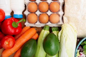 Groceries on a wooden background. Vegetables, eggs and other food