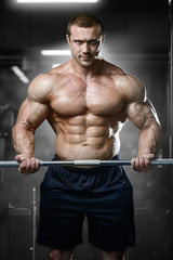 Fototapeta na wymiar Brutal strong bodybuilder athletic muscular men pumping up muscles with dumbbells