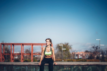 Pretty woman performs exercising outdoors in the park.