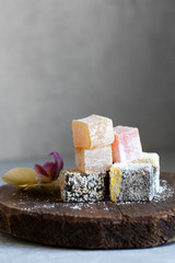 Turkish delight on a wooden tray with a flower.