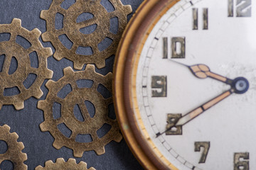 Fototapeta na wymiar Antique pocket watch and old vintage hour metallic gears on natural stone background.