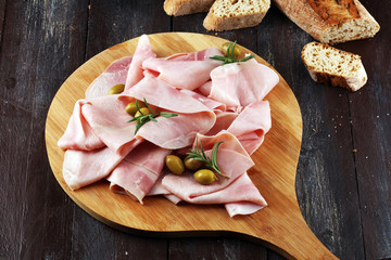 Sliced ham on wooden background. Fresh prosciutto. Pork ham sliced.