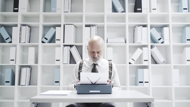 Senior businessman typing on a typewriter