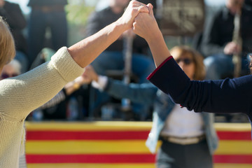 People dancing catalan typical Sardanas in the street and an orchestra during a national traditional festival. Empty copy space for Editor's text.