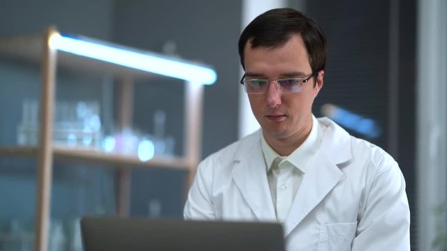 The doctor works in the office in the hospital for a laptop. Looks at the x-ray of the skull. Talking Phone.