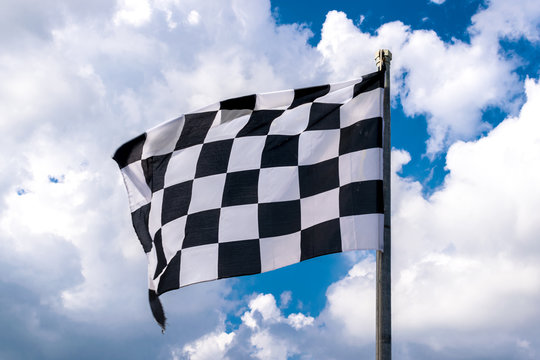 Checkered banner waving on blue sky and clouds