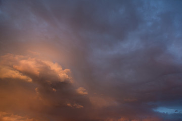 Naklejka na ściany i meble Dramatic dark cloudy stormy sky in the evening after sunset