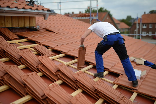 Dachdecker Bauarbeiter Mann auf Haus beim Ton Dachziegeln decken an der Arbeit