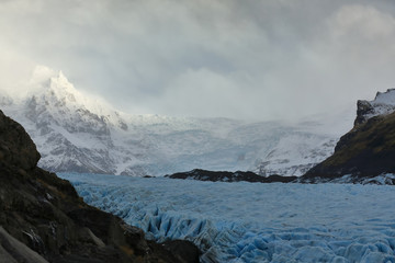 View of a glacier, background snowy mountains in Iceland