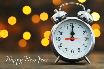 Happy New Year. Midnight clock and blurred lights in background