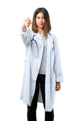 Doctor woman with stethoscope showing thumb down sign with negative expression on isolated white background
