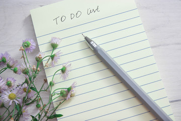 Naklejka premium day planning notebook, notepad, daisy flowers, top view, copy space.