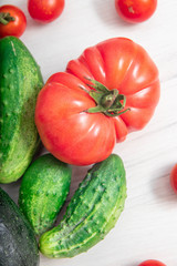 Heap of whole wet tomatoes and cucumbers, Top view, nutrition concept
