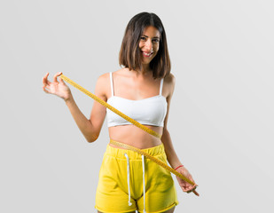 Sport woman with tape measure on grey background