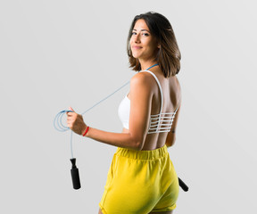 Sport woman with jumping rope on grey background