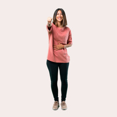 Full body of Young girl with pink shirt pointing with finger at someone and laughing a lot. Ideal for use in architectural designs