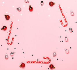 Christmas background with and decorations and red Christmas candies. Top view, flat lay. Bright and festive greeting card. Copyspace for text.