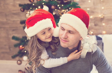 Dad and daughter, Christmas hat, tree, gift box