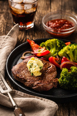 Grilled Beef steak with garlic butter and vegetables. Meat with grilled bell pepper, broccoli and onions.