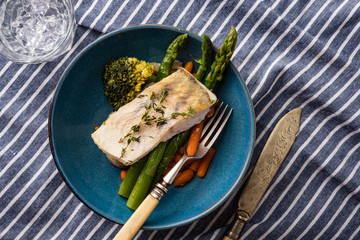 Pike perch fillet with asparagus, broccoli and carrots. Fried fish with stewed greens
