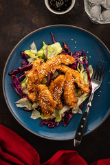 Salad with warm glazing chicken, sprinkled with sesame seeds. Chinese cuisine. Asian culture