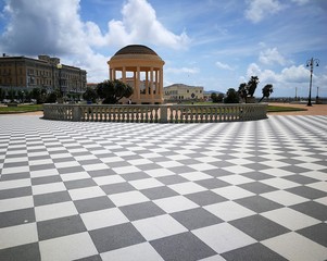Piazza con tempio circolare e pavimentazione a scacchiera, la foto ritrae piazza Mascagni a Livorno