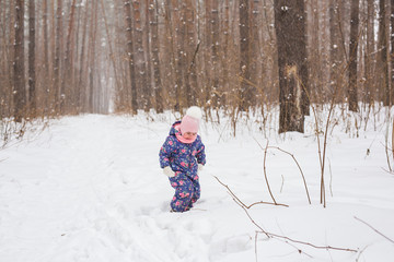 Childhood and children concept - baby girl walk in the winter outdoors