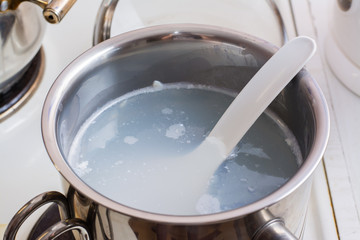 Dirty pan soaked after boiling milk porridge is on the stove