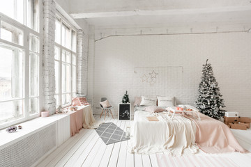 Christmas morning, Breakfast in bed, coffee and desserts. Loft style apartments. Bed in the bedroom, high large Windows. Brick wall with candles and Christmas tree. White color.