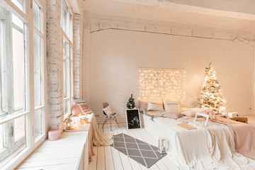 Christmas morning, Breakfast in bed, coffee and desserts. Loft style apartments. Bed in the bedroom, high large Windows. Brick wall with candles and Christmas tree. White color.