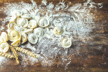 Italian ravioli, dumplings with meat on dark wooden old surface
