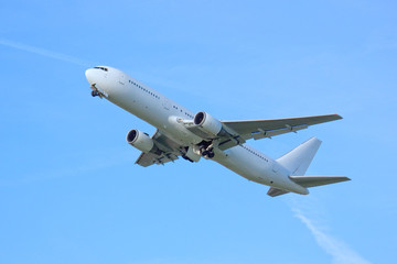 white airplaine 767 airborne take off into blue skies