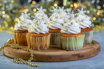 Cupcakes with cream and Christmas decorations.