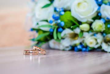 Wedding rings on the table next to the bouquet