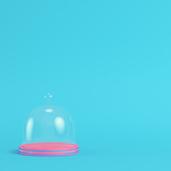 Pink plate with glass dome on bright blue background in pastel colors