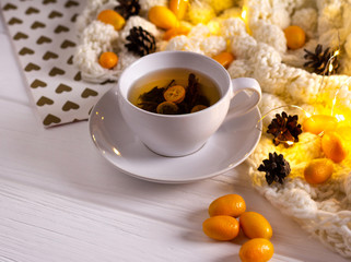 Winter hot tea with fruit in white cup on white table. 