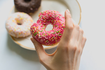 girl holds donut in her hand with icing