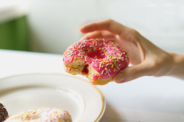 girl holds donut in her hand with icing