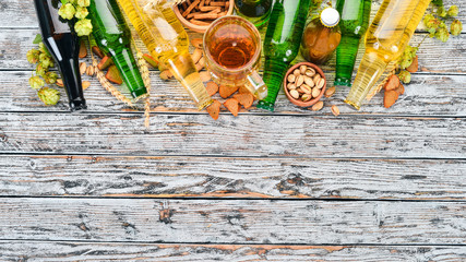Background beer and snacks. Hops, beer, chips, nuts. On a white wooden background. Free space for text. Top view.