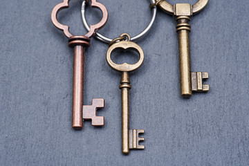 Old vintage metallic keys an natural stone background