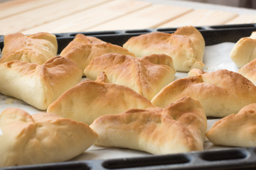 Sweet homemade yeast cakes triangular shape on food paper for baking. Front view. Food photography concept