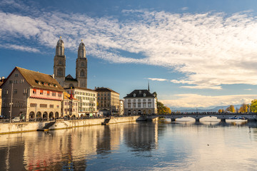 The iconic Grossm&uuml;nster Church in Z&uuml;rich with the Limmat River in the foreground