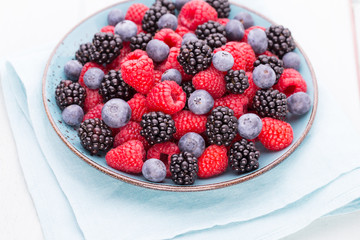 Fresh raspberries in a plate on a  vintage background.